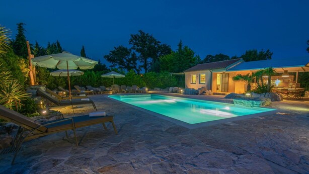 A stone patio with a swimming pool, lounge chairs, and umbrellas. - Wonderful private villa for 12 guests with WIFI, A/C, private pool, TV, terrace and pets allowed (Pazin)