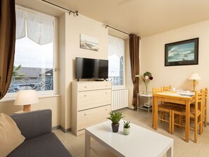 Relax in this stylish living space with a flat-screen TV, comfortable sofa, and dining area.