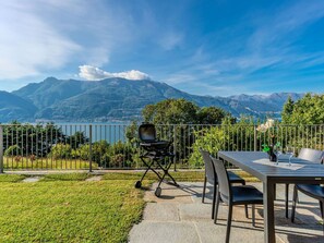 A terrace with a table and chairs, a lawn, and a mountain view. - Stunning private villa for 5 guests with pool, WIFI, TV and patio (Bellano)