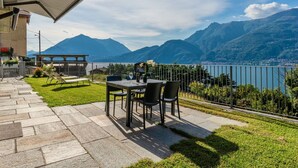 A terrace with a table and chairs, a view of mountains, and a lake. - Wonderful private villa for 5 guests with pool, WIFI, TV and patio (Bellano)