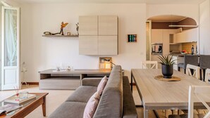 Una sala de estar moderna con un sofá, una mesa de comedor y una cocina al fondo.