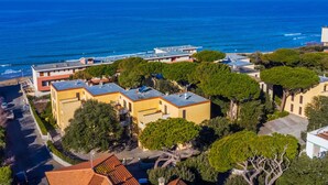 Una zona residenziale costiera con edifici moderni, vista libera sull'oceano e una strada ben tenuta.