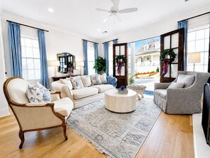 A spacious living room with a sofa set, a coffee table, and a chair. - The Nola, 3BR Luxe Stay by Velvet Ditch Villas (Oxford)