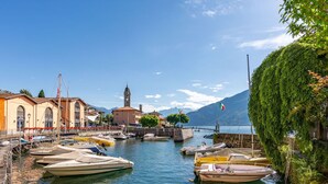 A marina with boats docked, a church with a bell tower, and a mountain in the background. - Lovely apartment for 4 guests with WIFI and TV (Vignola)