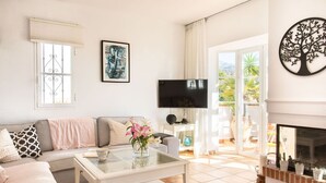 A living room with a sofa, coffee table, TV, and a fireplace. - Stunning private villa for 8 people with A/C, private pool, WIFI, TV and terrace (Frigiliana)