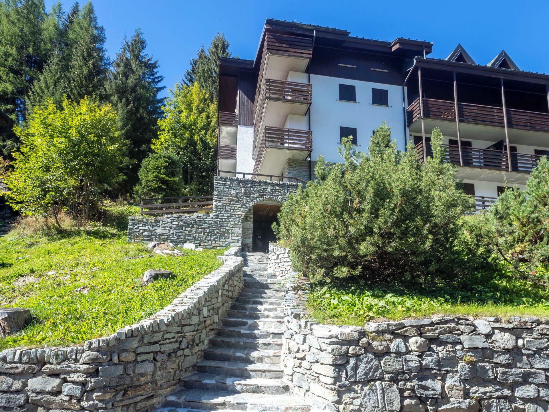 A stone staircase leading to a building with multiple balconies.