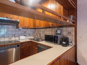 A kitchen with wooden cabinets, a dishwasher, a microwave, a toaster, and a coffee maker. - Nice apartment for 5 guests with WIFI, TV and terrace (Madesimo)