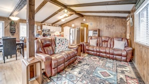 A spacious living room with leather sofas, a dining area, and a kitchen. - 2 Fire Pits & Covered Deck: Cabin in Happy Jack! (Happy Jack)