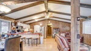 A spacious kitchen with wooden beams, a bar area, and leather seating. - 2 Fire Pits & Covered Deck: Cabin in Happy Jack! (Happy Jack)