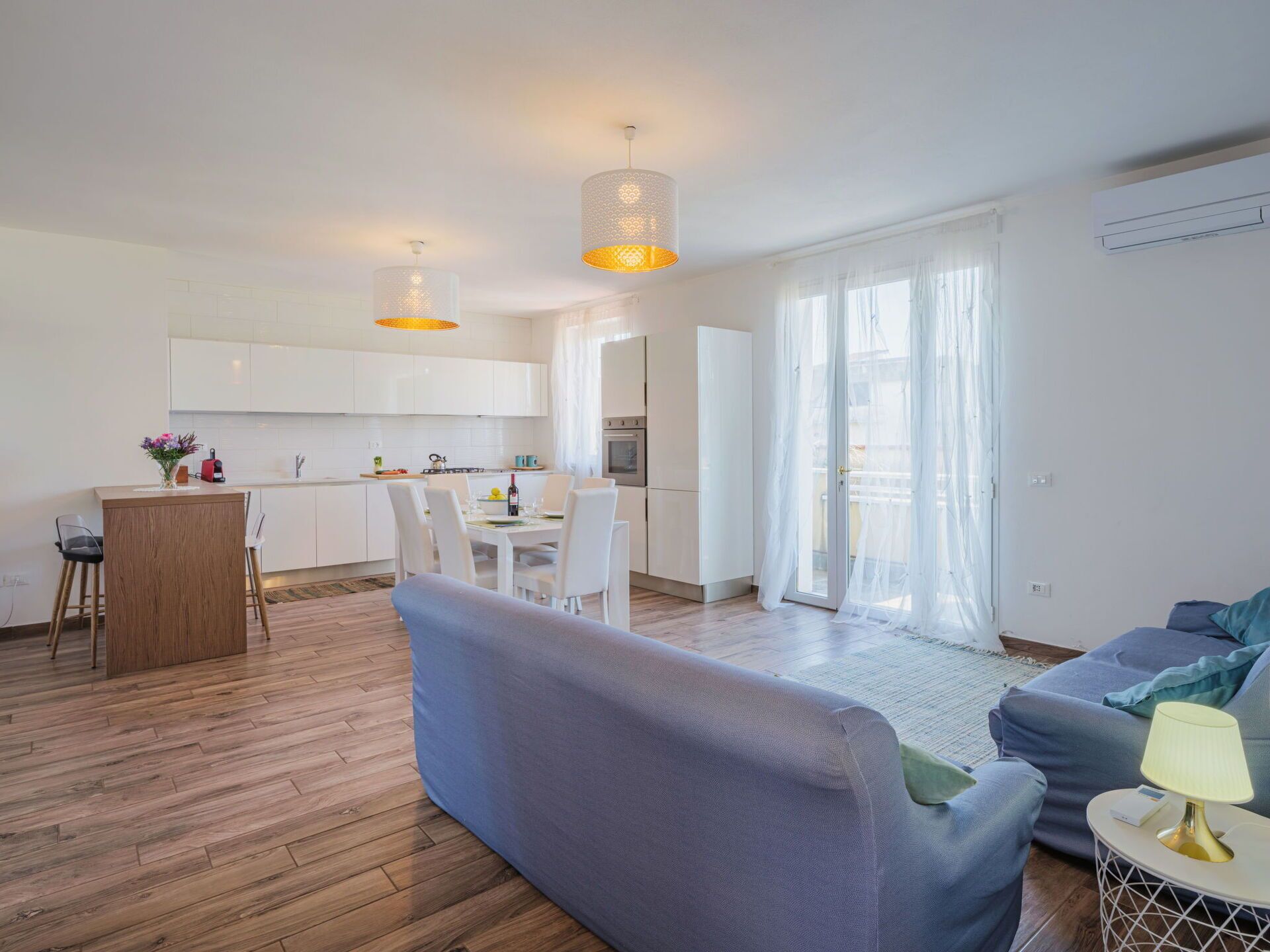 Un appartamento moderno con cucina, zona pranzo e soggiorno.