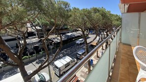 A balcony with a view of a street lined with parked cars and trees. - Beautiful apartment for 6 guests with A/C, WIFI, TV and terrace (Castell-platja D'aro)