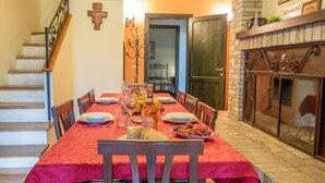 Un espace repas avec une nappe rouge, des chaises en bois et une variété de plats et de boissons.