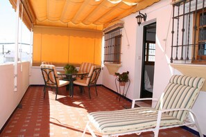 Enjoy a tranquil retreat on this balcony with a round table and four chairs, perfect for a morning coffee or evening relaxation.