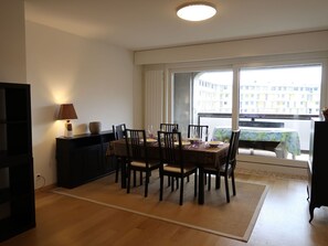 Enjoy meals in this dining area with a table for four, surrounded by comfortable chairs and a view of the building outside.