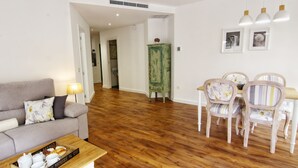 Una sala de estar con sofá, mesa de centro y comedor con sillas y mesa.