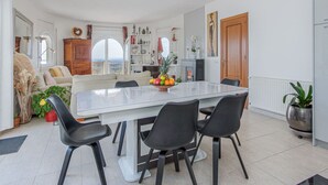 A modern kitchen with a large island, black chairs, and a dining table.