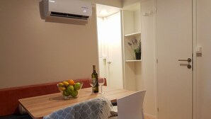 A dining area with a wooden table, two chairs, a bowl of fruit, a wine bottle, and a potted plant. - Beautiful private villa for 6 guests with pool, A/C, WIFI, TV and terrace (Umag)