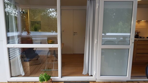 A sliding glass door leading to a balcony with a wooden floor and a potted plant. - Beautiful private villa for 6 guests with pool, A/C, WIFI, TV and terrace (Umag)