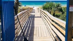 A wooden boardwalk leading to a beach with clear blue water. - Surfside Serenity at Bidawee PCB (Panama City Beach)