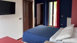 Une chambre d’hôtel avec un lit, une télévision, une porte et une fenêtre avec des rideaux.