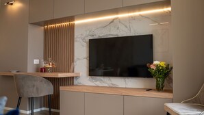 A modern kitchen with a built-in TV, wooden cabinets, and a marble backsplash. - Nice apartment for 3 guests with A/C, WIFI, TV and terrace (Roseto Degli Abruzzi)