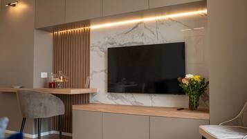Eine moderne Küche mit integriertem Fernseher, Holzschränken und einer Marmor-Spritzschutzwand.