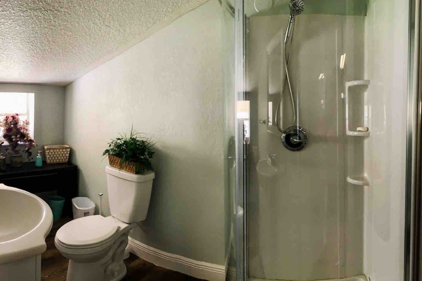 Ein Badezimmer mit Duschkabine, Toilette und Waschbecken.