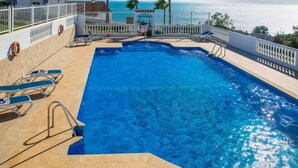 A swimming pool with a view of the ocean, surrounded by a white fence and palm trees. - Beautiful apartment for 4 guests with WIFI, pool, A/C, TV, terrace and pets allowed (Torrox)