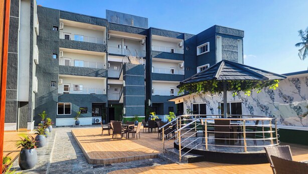 A multi-story building with outdoor seating and a staircase. - Presken Hotel Residence  (Lagos)