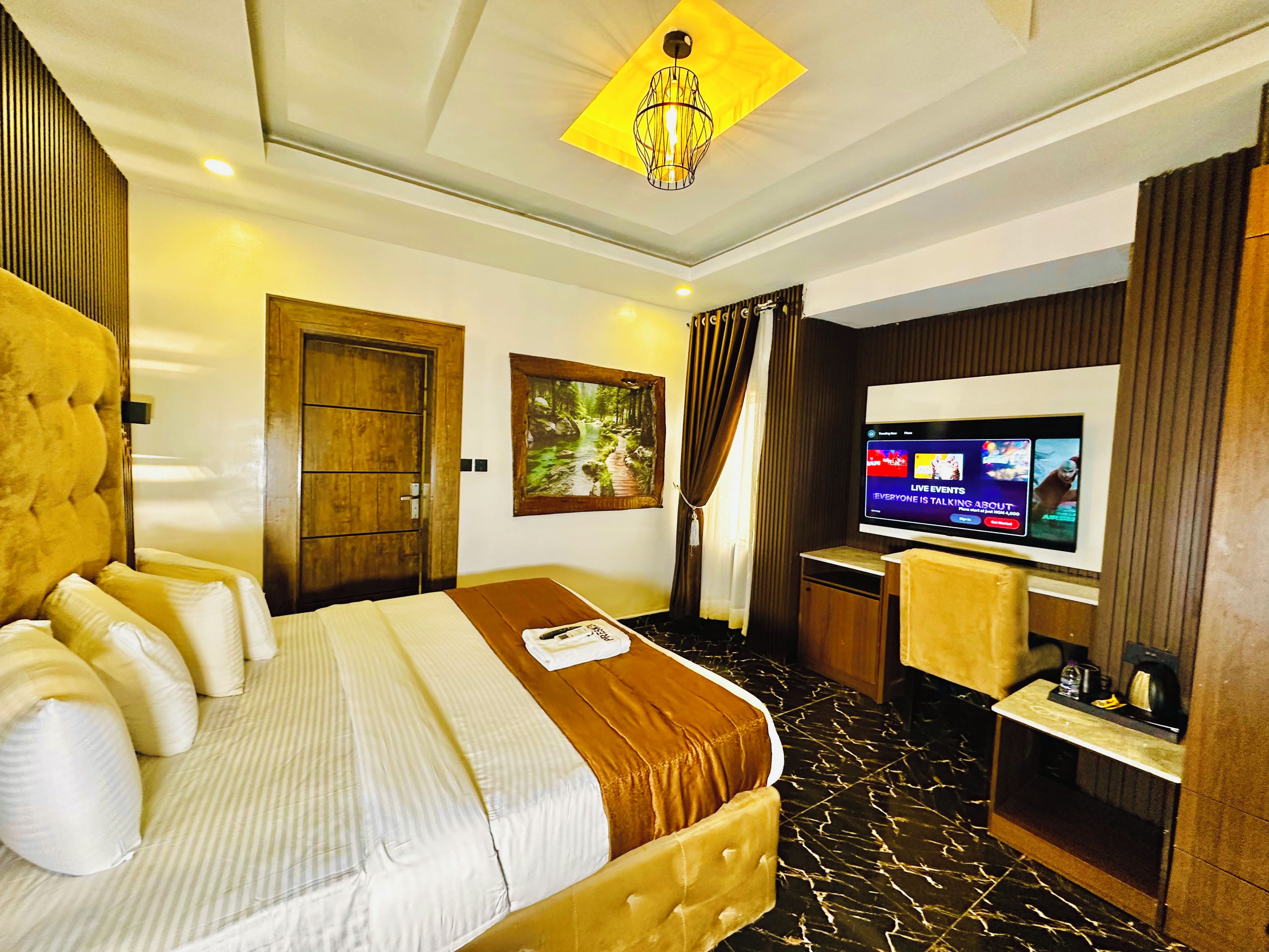 Une chambre d’hôtel avec un grand lit, une télévision, un bureau et une armoire.
