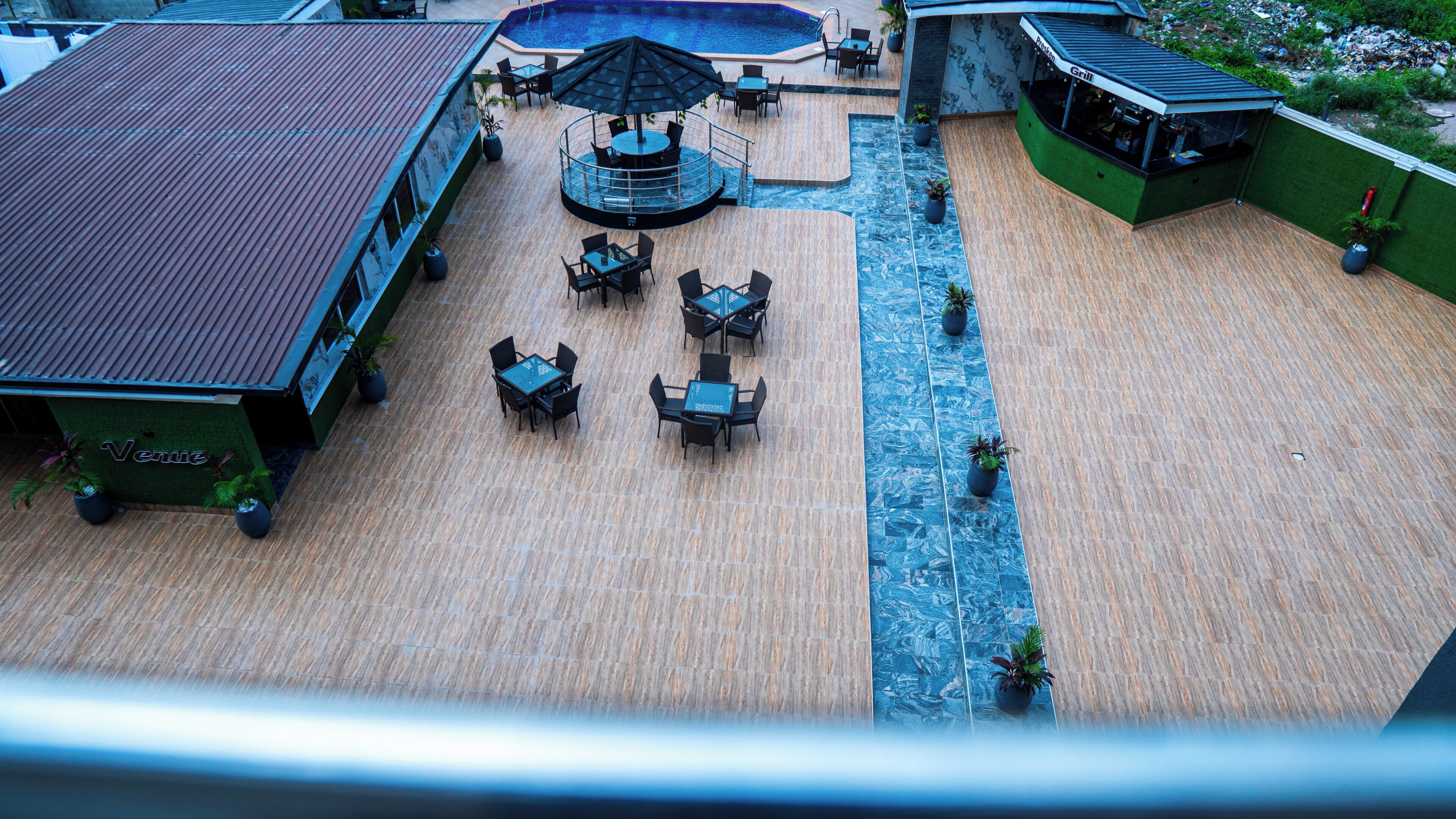 An outdoor terrace with a pool, seating areas, and a restaurant named 'Grill'.