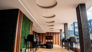 A modern interior with a green wall, wooden paneling, and a ceiling with circular recessed lighting. - Presken Hotel Residence  (Lagos)