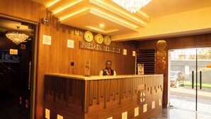 A reception desk with clocks, a chandelier, and a sign reading 'PRESKEN RESIDENCE.' - Presken Hotel Residence  (Lagos)
