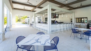An outdoor patio area with a bar, seating, and ceiling fans. - 4342 - Great Family Home near Disney, Pool & Spa - Storey Lake Resort (Kissimmee)