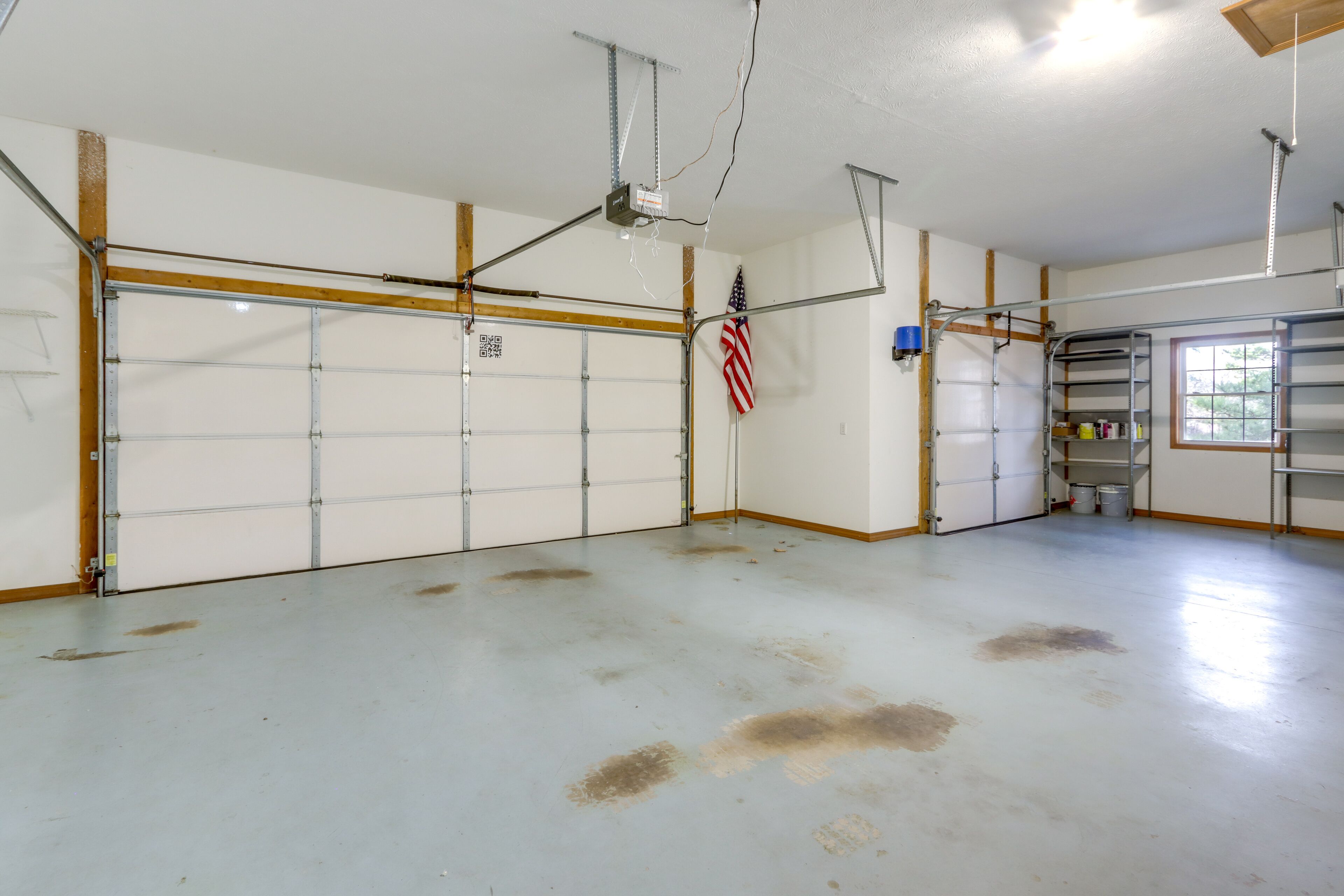 Eine Garage mit sauberem, weißem Boden und einer großen amerikanischen Flagge an der Wand.