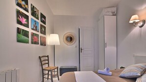 A bedroom with a bed, a chair, a lamp, a wardrobe, and wall art. - Stunning  villa for 4 people with WIFI, TV, terrace and pets allowed (Saint-denis-d'oléron)
