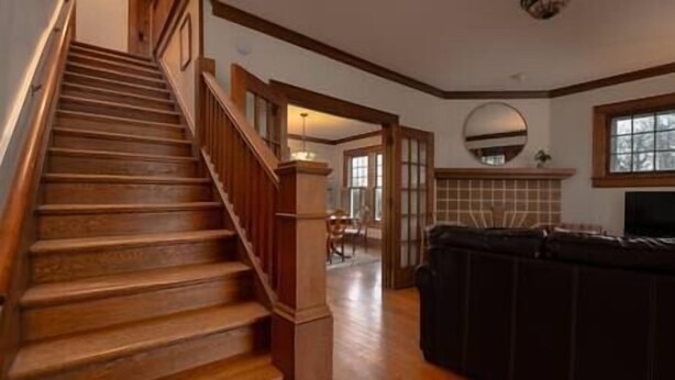 A staircase leading to a living area with a fireplace and a television. - Central Charleston Craftsman (Charleston)
