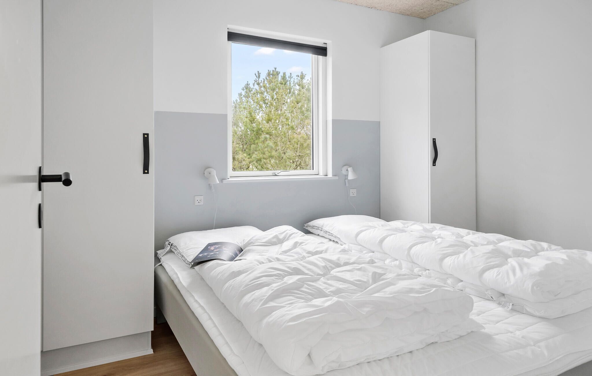 Un dormitorio con cama, ventana y armario.