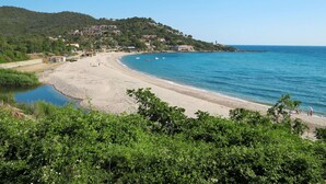 A coastal beach with a sandy shore, a small cove, and a hillside with buildings. - Lovely apartment for 6 guests with A/C, pool, WIFI, terrace, pets allowed and panoramic view (Tarco)