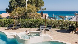 A swimming pool with a hot tub, lounge chairs, and a view of the sea. - Lovely apartment for 6 guests with A/C, pool, WIFI, terrace, pets allowed and panoramic view (Tarco)