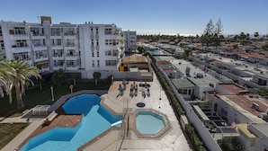 A resort with multiple swimming pools, a rooftop bar, and a view of the surrounding buildings. - Stunning  villa for 4 guests with pool, WIFI, A/C, TV, terrace and pets allowed (Playa Del Ingles)