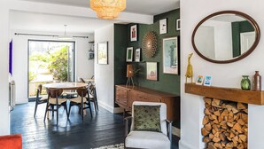 Un soggiorno moderno con zona pranzo, camino e un grande specchio.