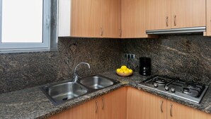 Eine Küche mit Granit-Arbeitsplatten, Edelstahlgeräten und Holzschränken.