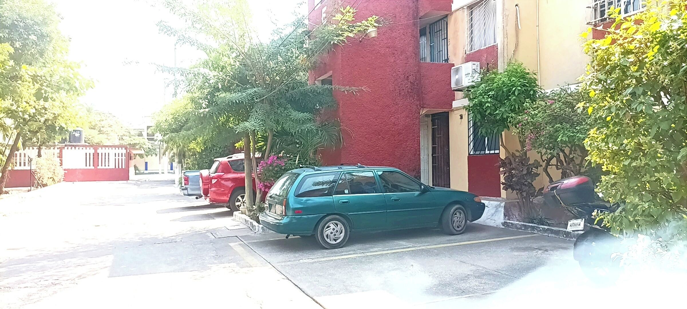 A street view with parked cars and buildings.