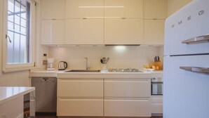 Een moderne keuken met witte kasten, een roestvrijstalen spoelbak en een inbouwoven.