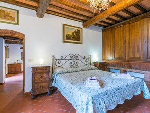 Une chambre à coucher avec un lit, une armoire en bois et un lustre.