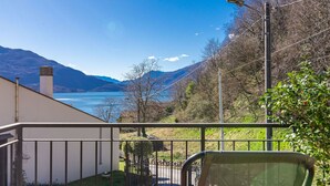 A balcony with a view of a lake and mountains.