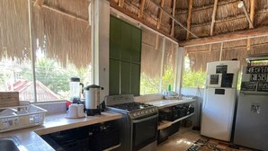 A kitchen with a gas stove, sink, and a refrigerator.