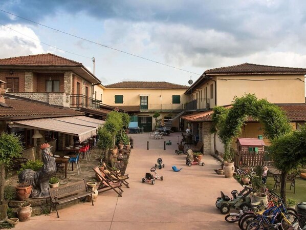 Une cour intérieure avec des bâtiments, des espaces de repos en plein air et des vélos.
