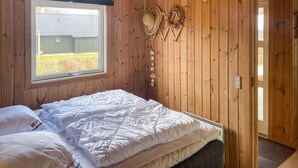 A wooden room with a bed, a window, and a door. - Stunning home in Sjølund with kitchen (Sjølund)